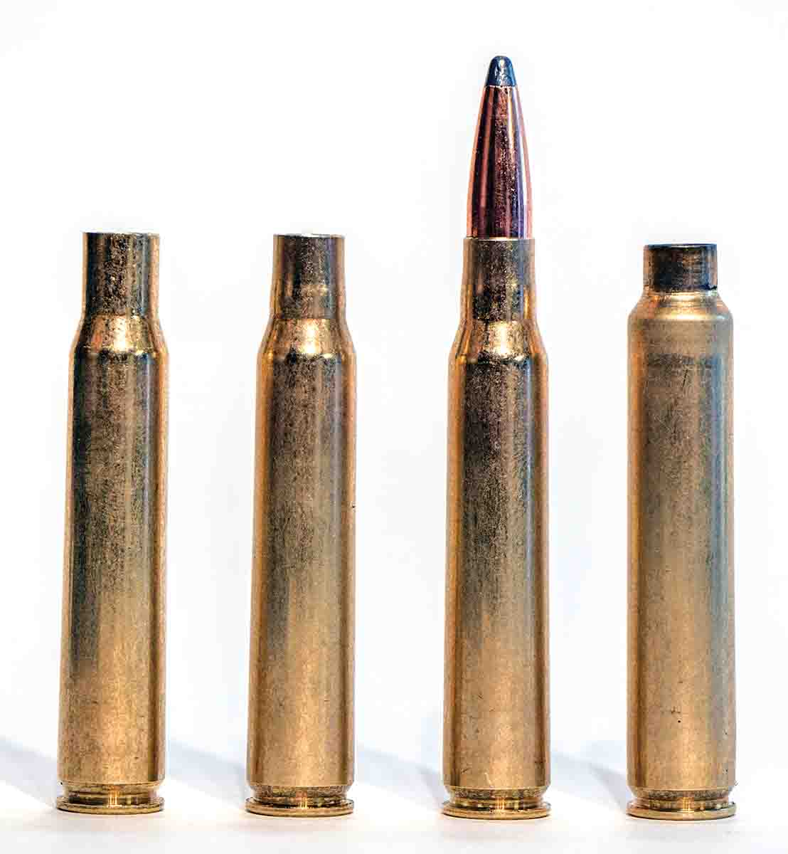 Making 7mm JRS cases from .30-06 brass requires (left to right): partially neck-sizing the case, loading it with a midrange .280